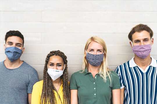 Multiracial friends wearing face mask for preventing and stop corona virus spread - Youth millennial generation lifestyle during covid-19 crisis