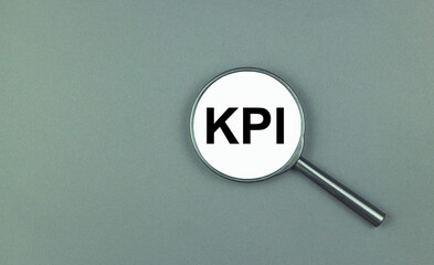 KPI inscription in black letters on a magnifying glass. Key performance indicator concept.