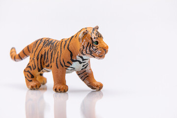 close up of a baby tiger from a plastic toy isolated on a white background