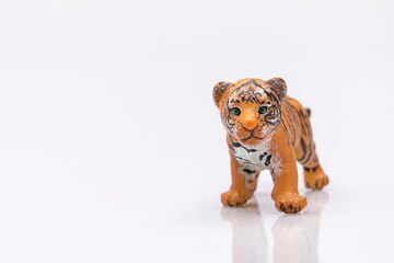 close up of a baby tiger from a plastic toy isolated on a white background