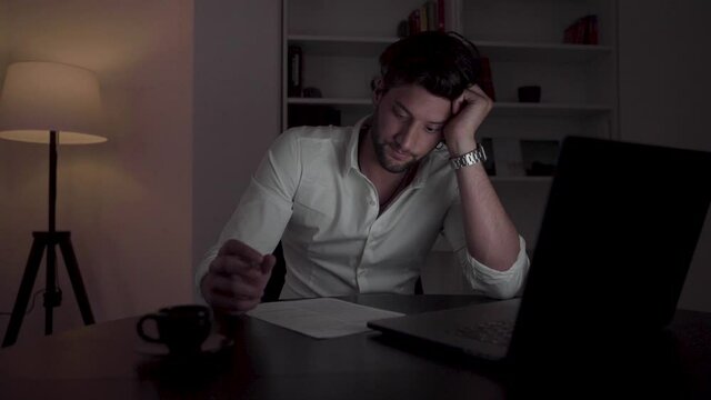 Young handsome businessman isolated working later. 
Working hard 