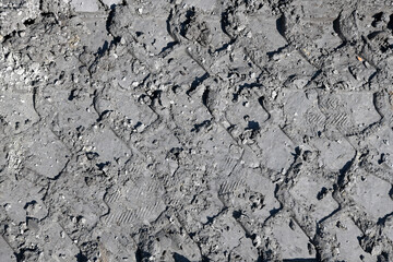 Traces of vehicle tires in clay.  Interesting mud background. Muddy soil texture.