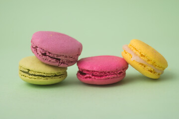 Fototapeta na wymiar Closeup of french traditional macarons on green background