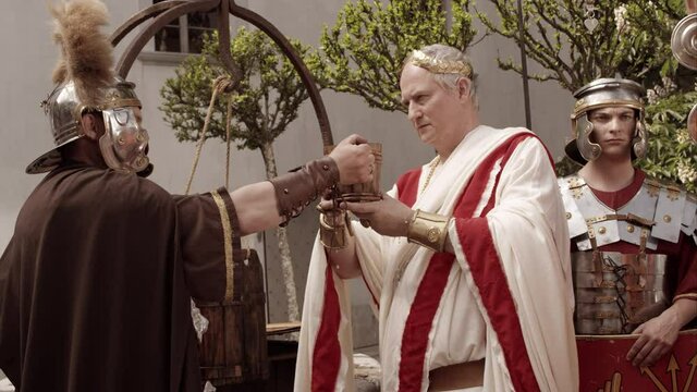 Centurion Offers Wooden Cup To Emperor Who Drinks From It