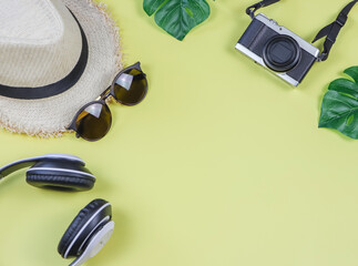 summer , holiday concept , Top view or  flat lay of travel accessories ,camera , sunglasses , headphone and hat on yellow background.