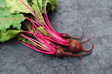 Group of chard with beetroots. Young beetroot with fresh leaves on dark background - obrazy, fototapety, plakaty