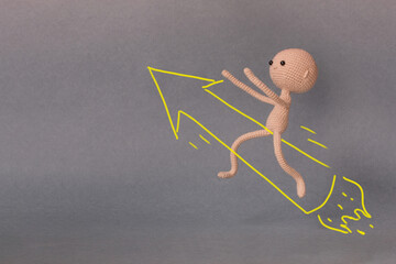 A toy man on a gray background with copy space. Presentation PowerPoint or Keynote. Motivational phrase. A sketch is drawn on top of the photo.Man flying on a rocket in the form of an arrow