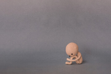 A toy man on a gray background with copy space. Cute amigurumi. Presentation PowerPoint or Keynote....