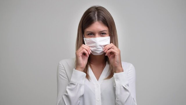 young girl works at the computer in her office and takes off her mask confident for the future