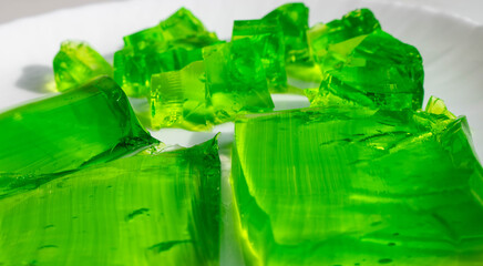 Delicious green jelly cube on white background