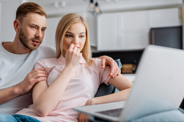 selective focus of couple watching movie on laptop