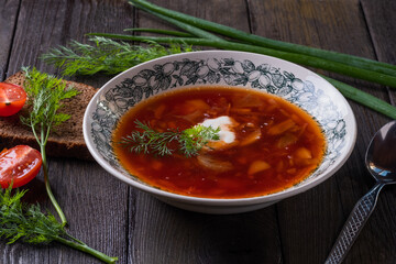 Bowl of red beet root soup borsch with white cream on wooden background, top view . Beet Root delicious soup . Traditional Ukrain food cuisine 