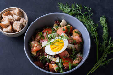 Salad with fresh vegetables  with red beans,  tomatoes,  dill, half egg,  toast Close up view