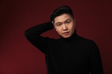 Fototapeta premium Image of confused asian man posing and looking at camera