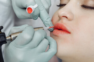 Woman having permanent makeup on lips in beauty salon