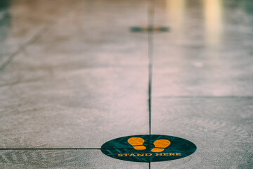 Stand here foot sign or symbol on the floor