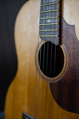 Obraz premium Acoustic guitar resting against a wooden background
