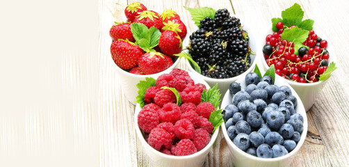 Variety of fresh berries in bowls, banner, header, headline