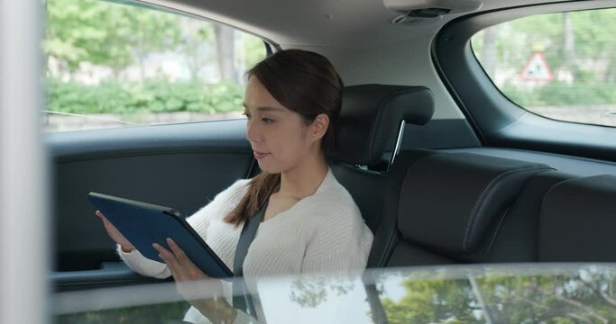 Woman check on tablet computer on car