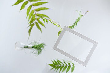 Beautiful flying green leaves background with white frame. Creative layout, nature concept. leaves levitation around wooden frame. mockup for season sale or natural product presentation. summer sales.