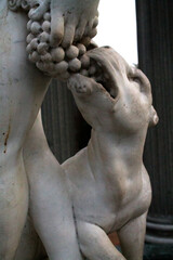 white statue of animal eating grapes