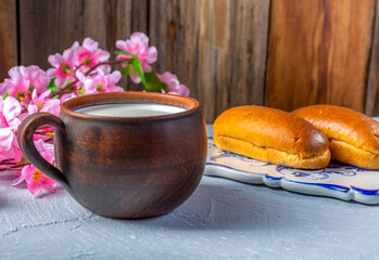 Breakfast rolls with chocolate filling and milk on a wooden rustic background