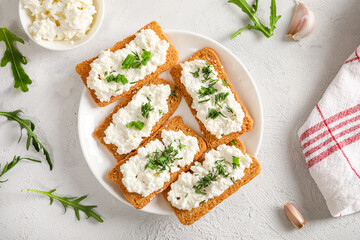 Healthy and tasty snack with crispy bread, cottage cheese and herb