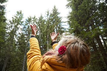 Fototapeta na wymiar Woman in nature holdings hands in the air and enjoying good natural vibes.