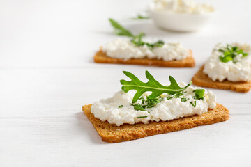 Fototapeta na wymiar Healthy and tasty snack with crispy bread, cottage cheese and herb