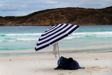Fototapeta na wymiar A striped lone umbrella on a deserted beach, Esperance, Western Australia