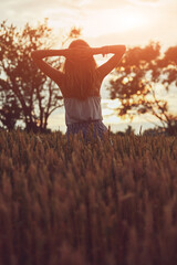 Young woman enjoying in a wheat field.