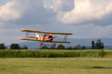 R/C biplane airplane landing on the grass