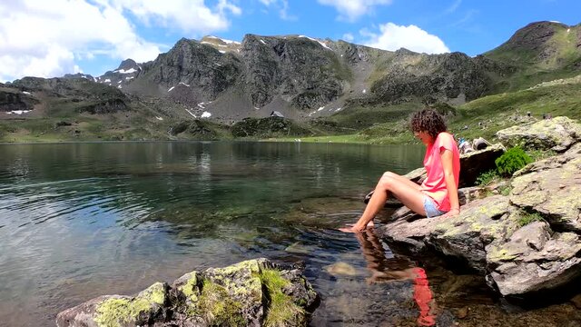 woman hiker and Lake Gentau in French Pyrenees. Mountains, valley, laggon.