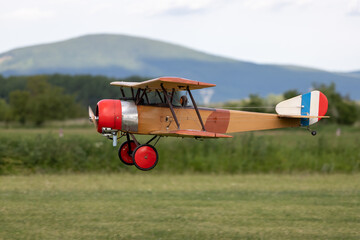 Obraz na płótnie Canvas R/C biplane airplane landing on the grass