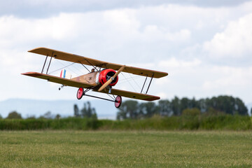 Fototapeta na wymiar R/C biplane airplane landing on the grass