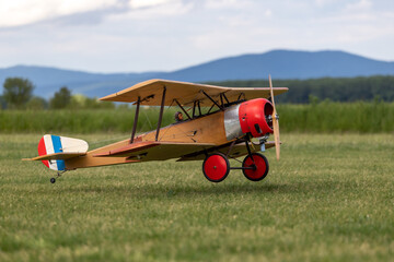 R/C biplane airplane taking off the grass with engine running