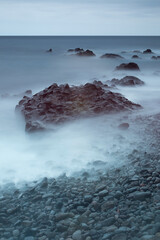 Long exposure photo of beach with rocks