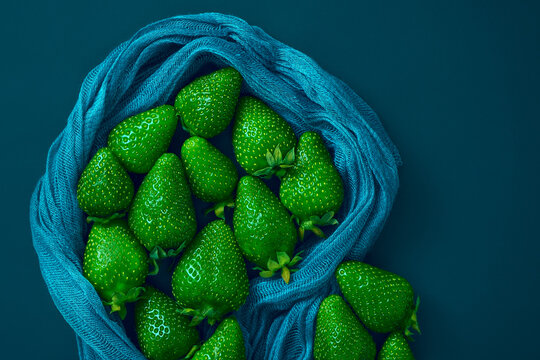 Green strawberries with a top view, a creative image of modified berries recolored in an atypical color