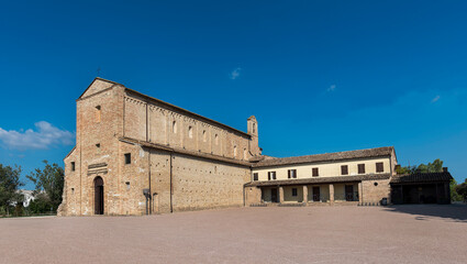 Fototapeta premium Carolingian church, view of the front main entrance , green lawn in the foreground, blue sky