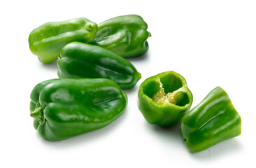 pimientos verdes enteros y cortados sobre fondo blanco. Whole and sliced ​​green peppers on white background.