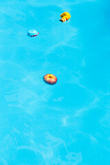 Naklejka premium apple and toys floating in the water of a pool