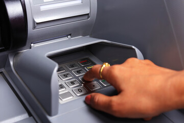 Close Up of a Female Hand entering Personal Identification Number at an ATM Machine to Withdraw Cash. Close Up. ATM Transaction. Pressing buttons of a Keypad. Banking. Soft Focus. 