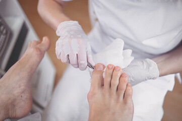 Professional medical pedicure procedure close up using nail clippers instrument. Patient visiting...