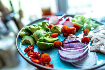 Healthy vegan lunch plate. Avocado,  tomato, cucumber, red pepper, onion.