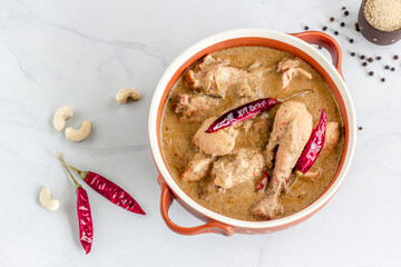 Chicken Rezala - Popular Eastern Indian Chicken with Gravy.  Chicken Rezala, Popular Eastern Indian Cashew Chicken with Gravy Top Down Photo with Assorted Spices on White Background
