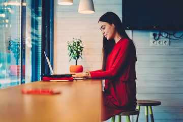 Portrait of positive skilled female freelancer making plans 