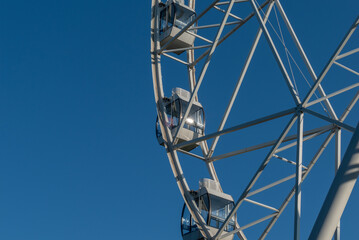 White Ferris wheel against the blue sky