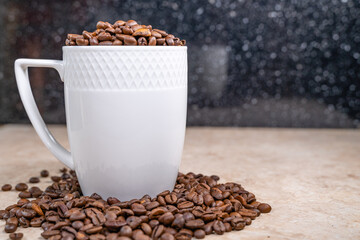a white cup filled with roasted cinnamon coffee beans standing on brown marble surrounded by coffee beans