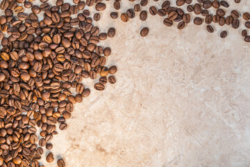sprinkled roasted coffee beans on white and yellow marble top view
