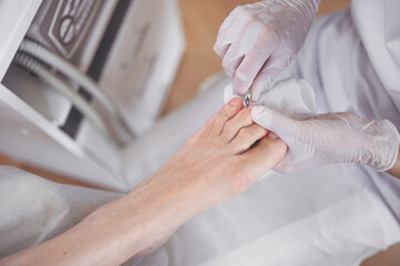Obraz na płótnie Canvas Professional medical pedicure procedure close up using nail clippers instrument. Patient visiting chiropodist podiatrist. Foot treatment in SPA salon. Podiatry clinic. Pedicurist hands white gloves